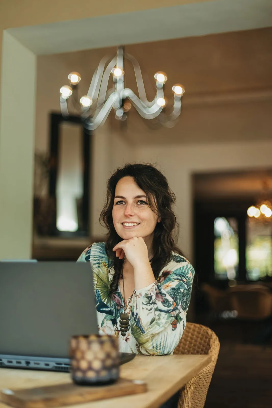 Simone Hervij, web designer for dog businesses, smiling behind her laptop